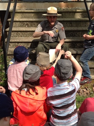 photograph of ranger talking with students, hands raised for questions
